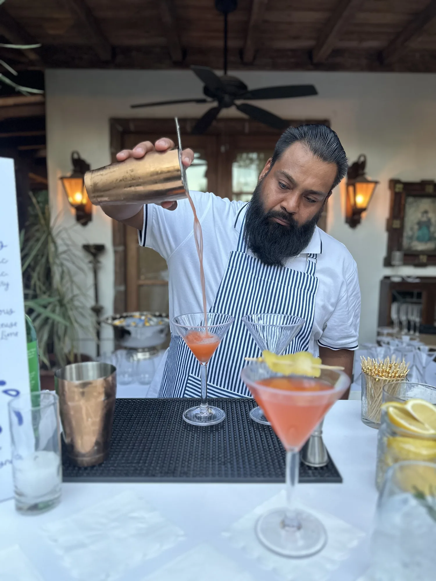 Bartender pouring freshly mixed signature cocktails.