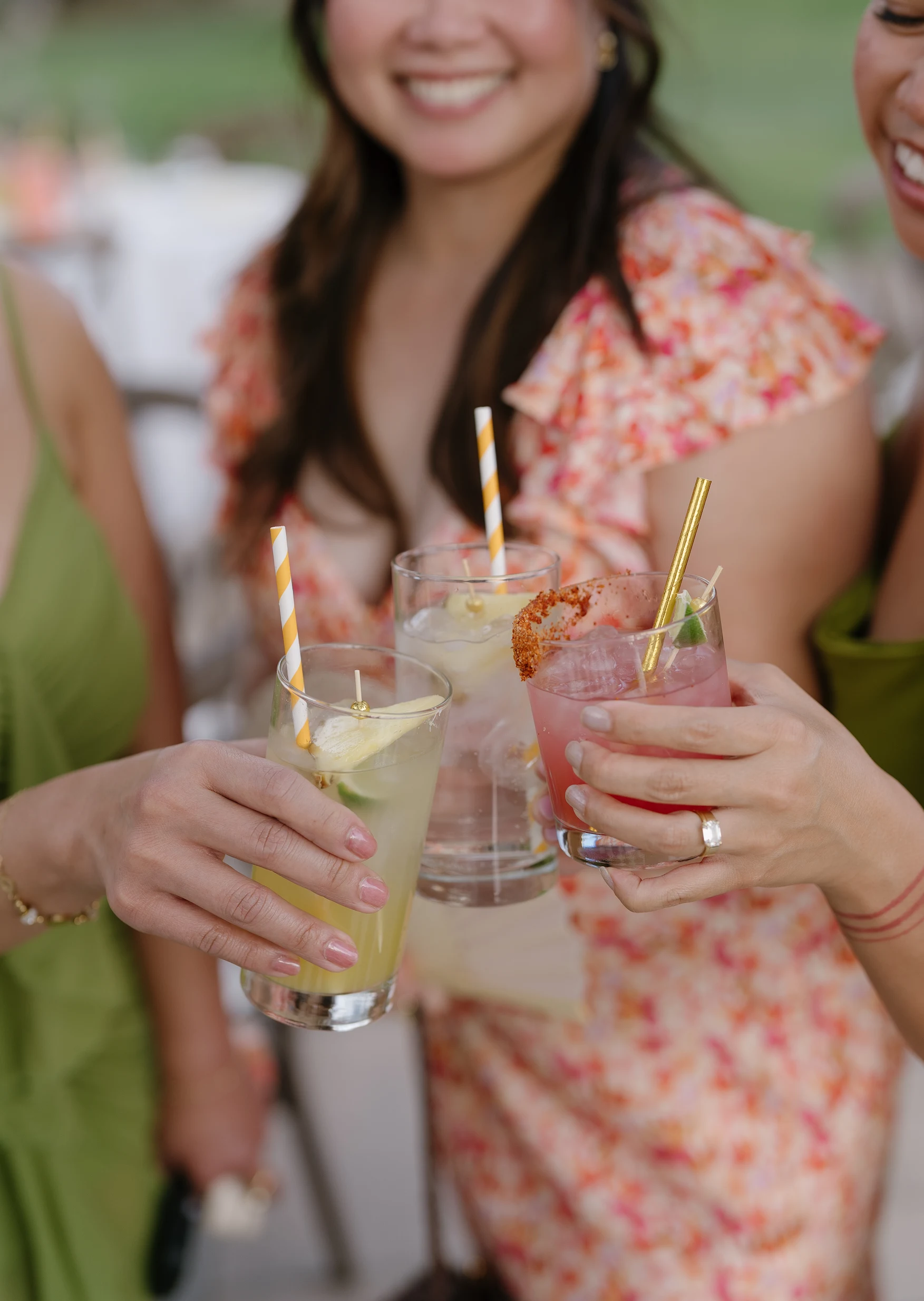 Wedding guests holding pale green and pink cocktails.