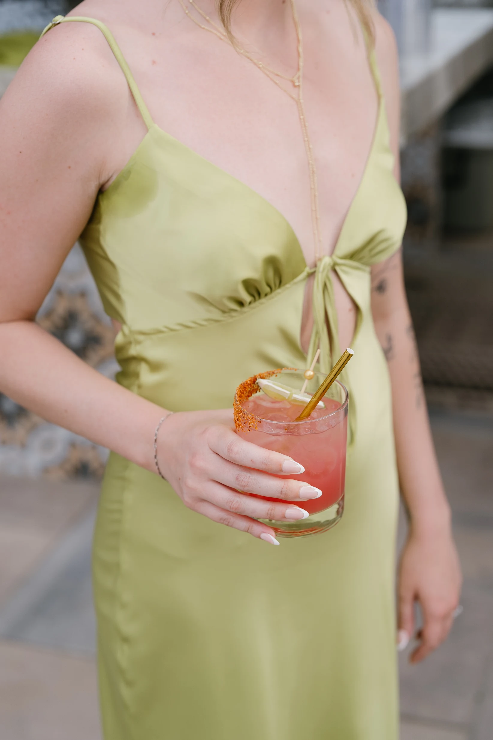 A wedding guest holding a pink signature cocktail.