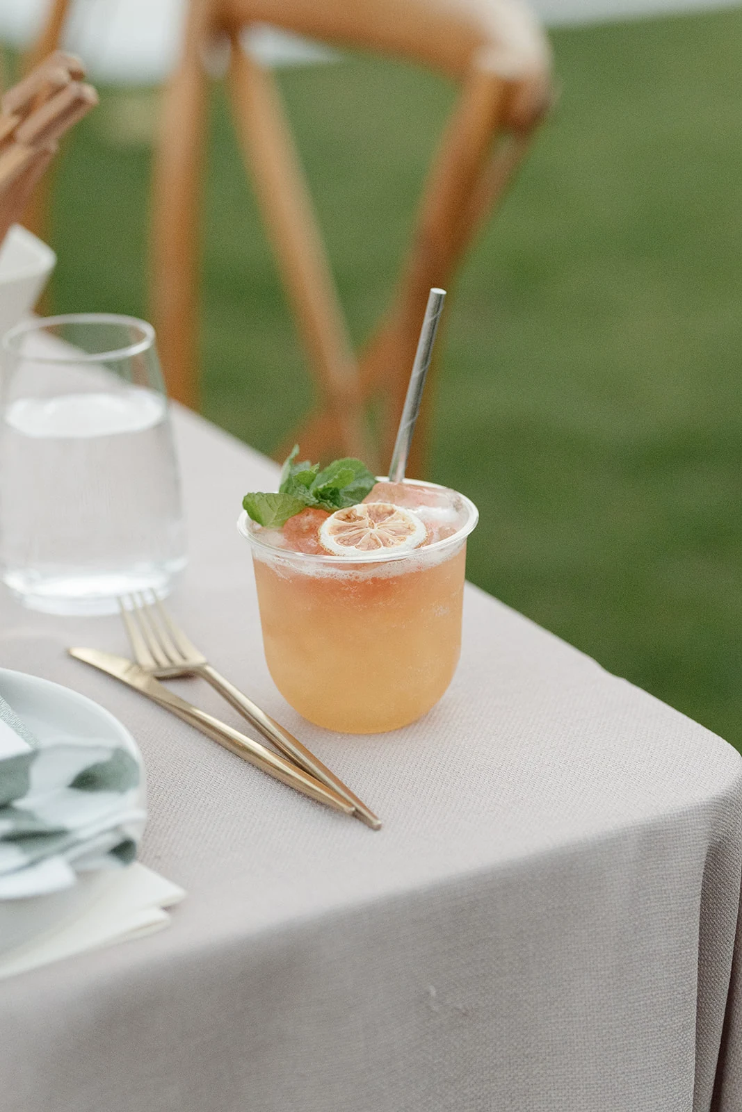 A peach cocktail at a wedding place setting.