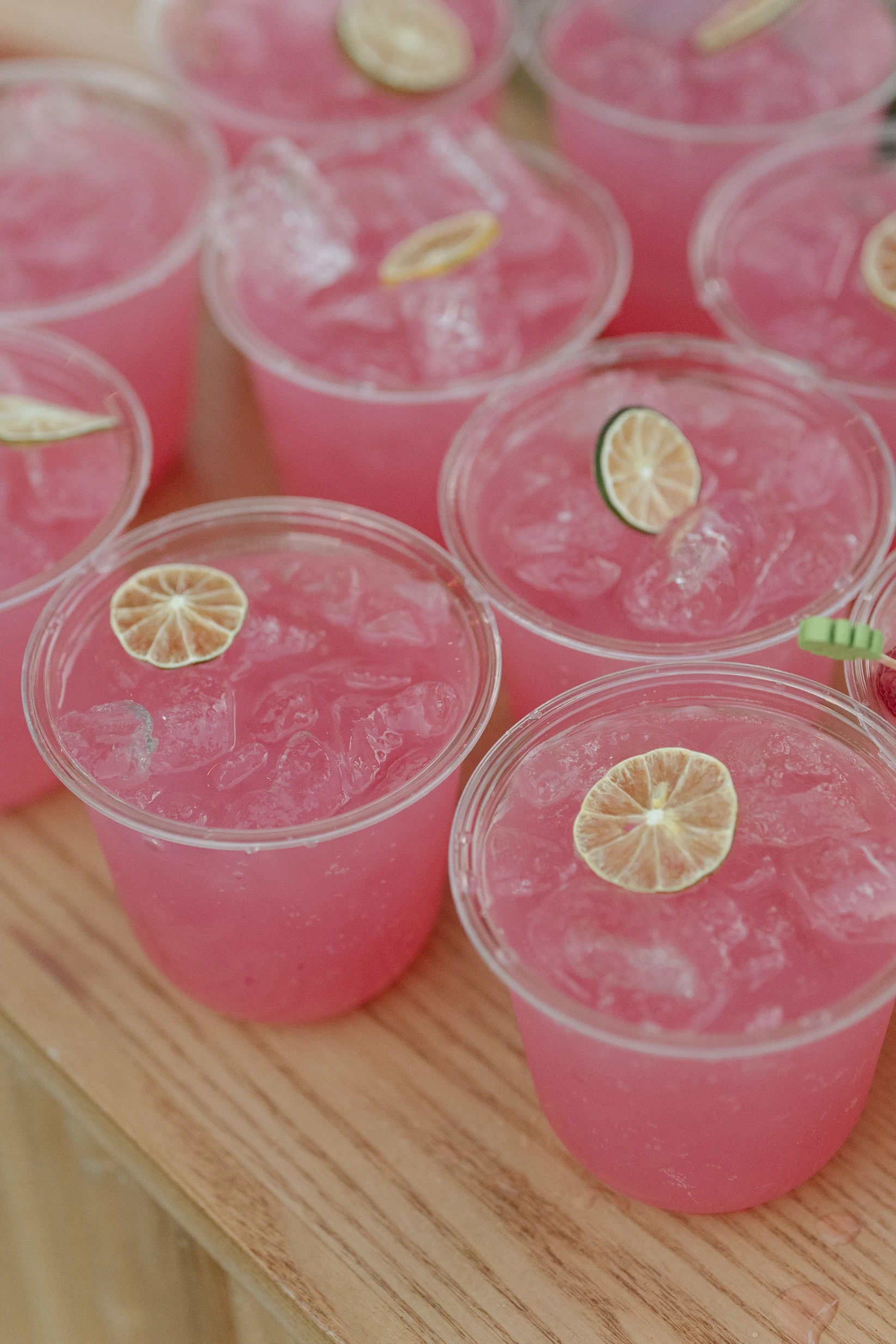 An overhead view of pink cocktails with lime wheels.