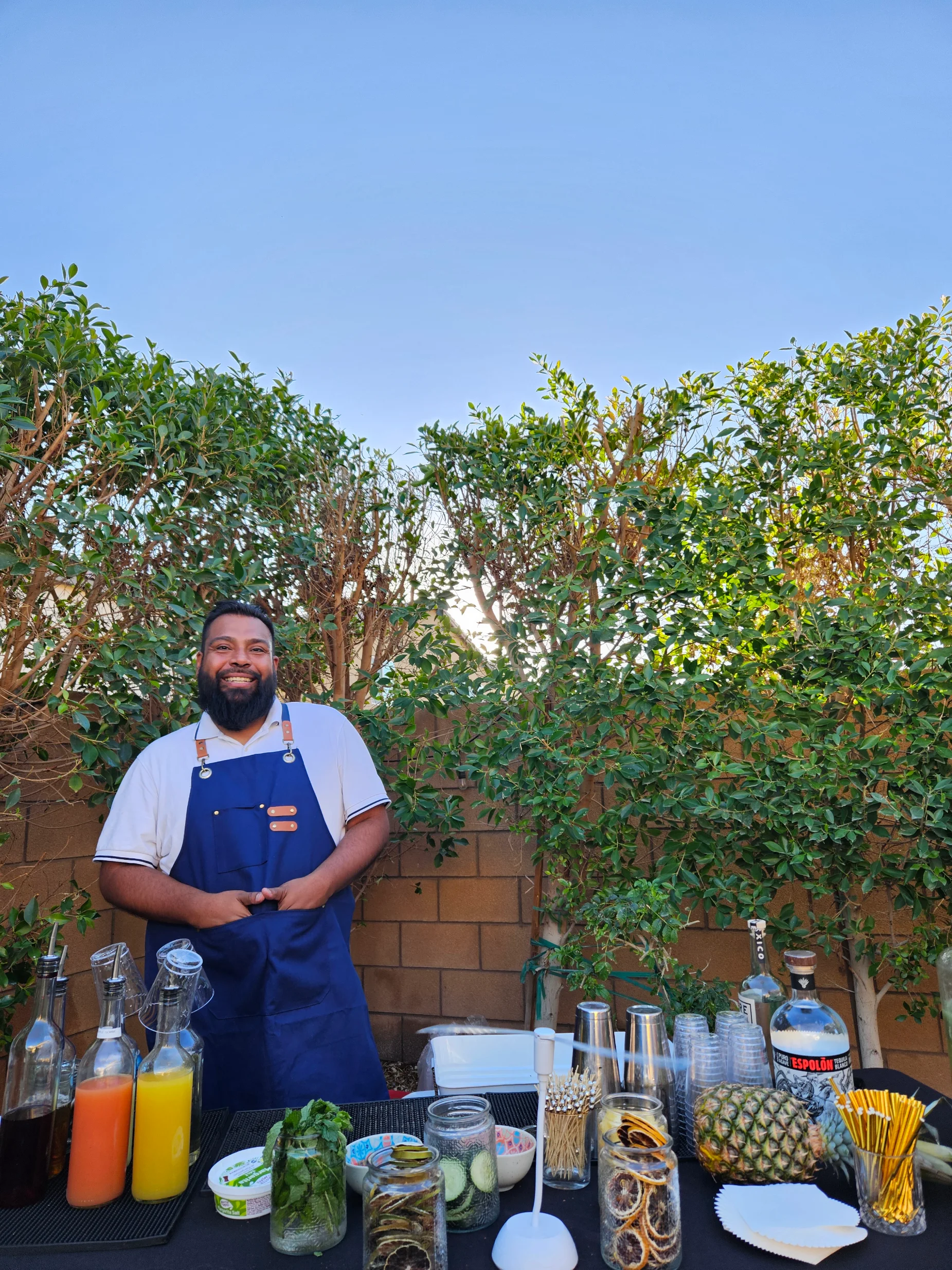 A smiling bartender standing outdoors at the event.
