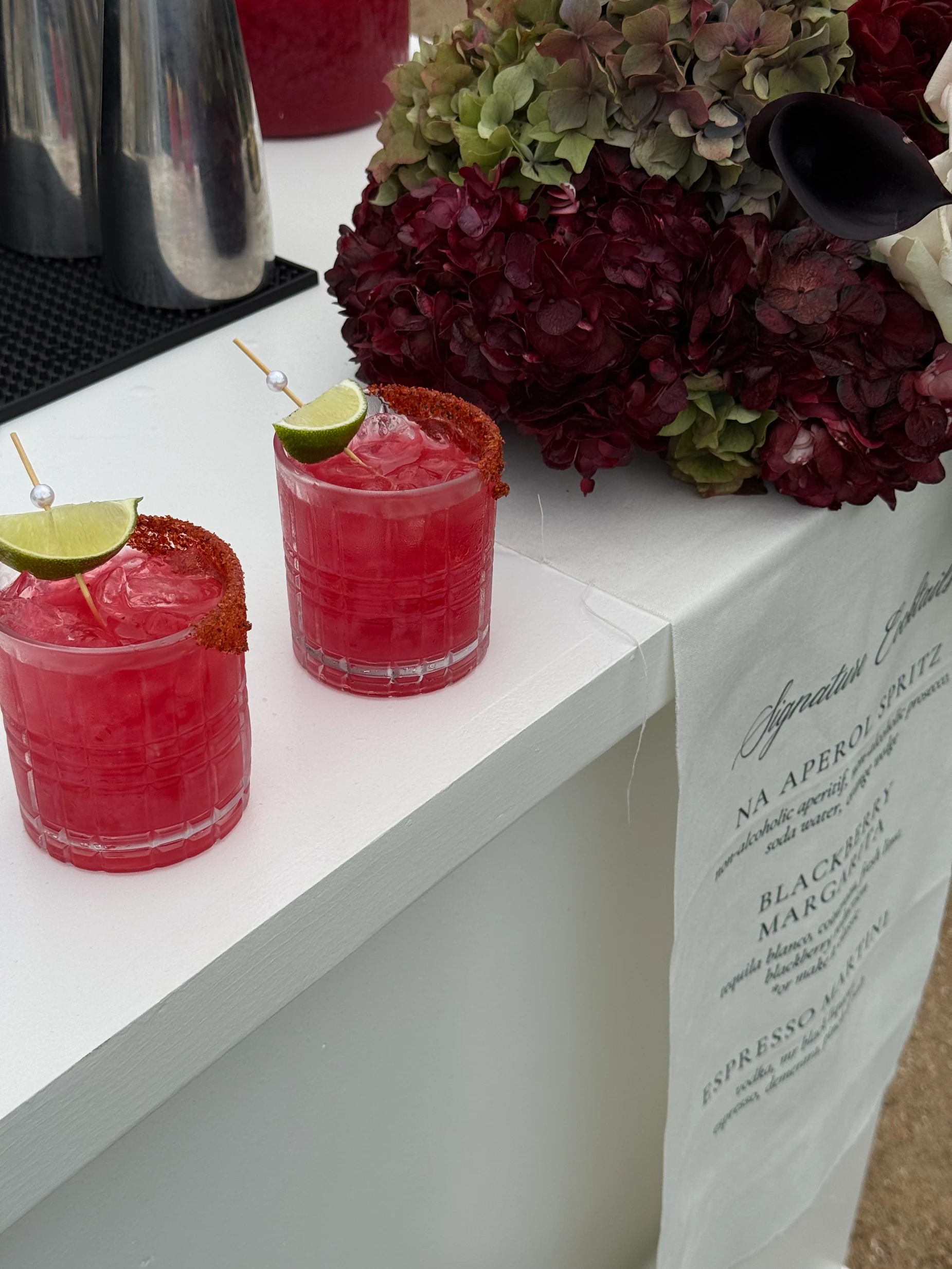 Red wedding cocktails displayed beside the menu.