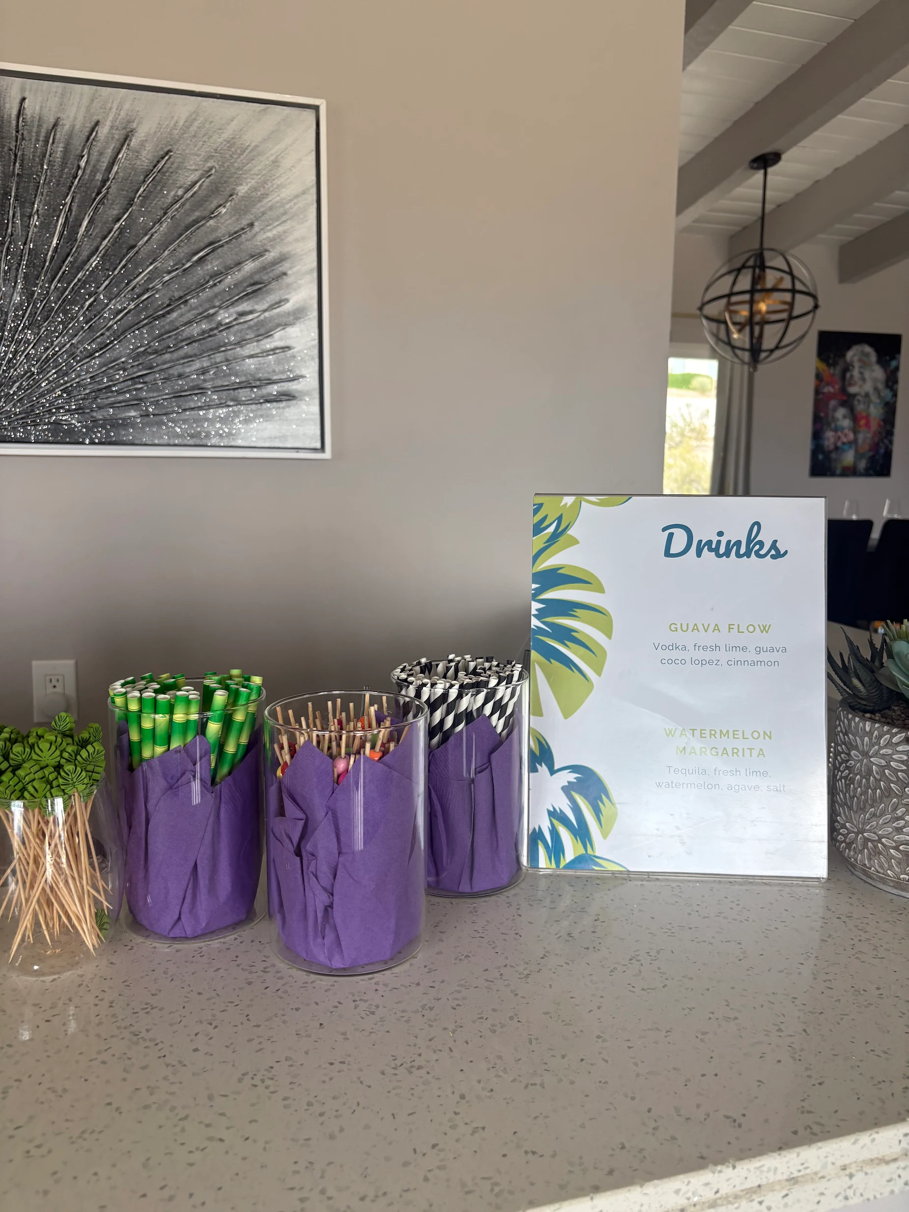 A custom drinks menu beside colorful reusable cups.