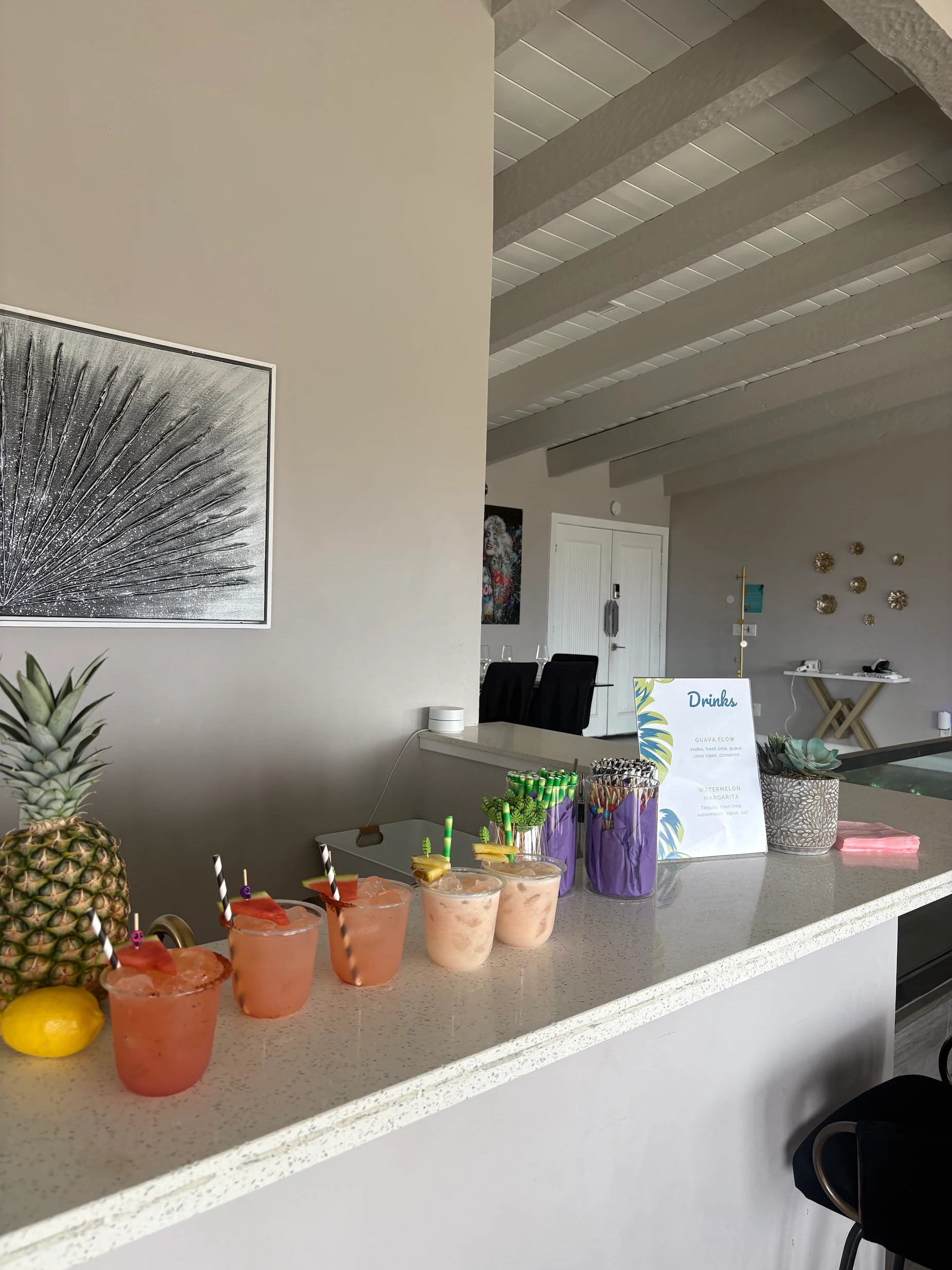 A party drink station with pineapple and colorful cups.
